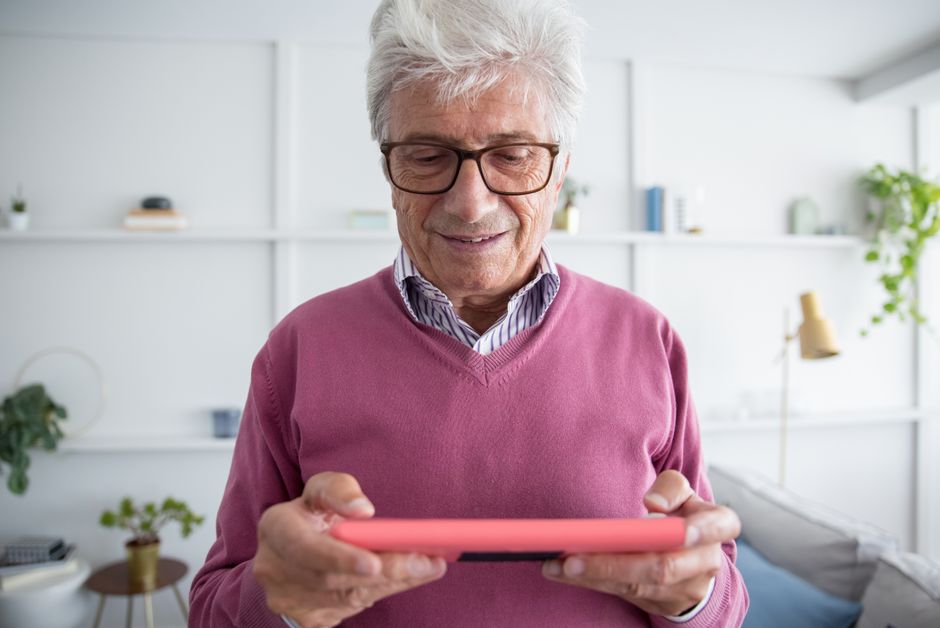 A busy adult unwinding with a tablet, playing a slow-paced simulation game with a cup of coffee nearby, representing relaxation.