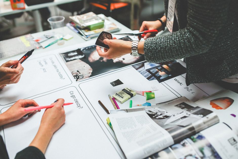 A diverse team from a marketing agency collaborating around a table, discussing content strategy and client pain points for effective service pages.