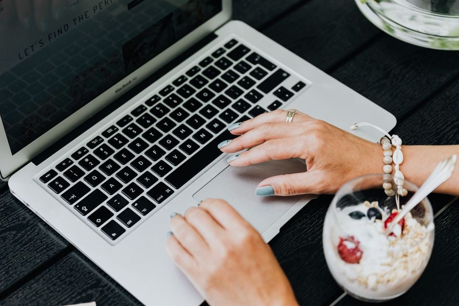 A busy professional in a modern office setting enjoying a bowl of yogurt with berries at their desk, illustrating healthy eating during a packed schedule.