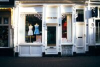 A cozy independent bookstore with a large display window and a warm interior, showcasing books and a comfortable reading nook.