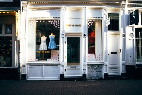 A cozy independent bookstore with a large display window and a warm interior, showcasing books and a comfortable reading nook.