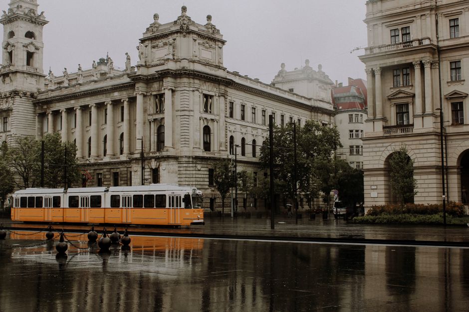A yellow tram characteristic of Lisbon moving through a historic street with passengers.