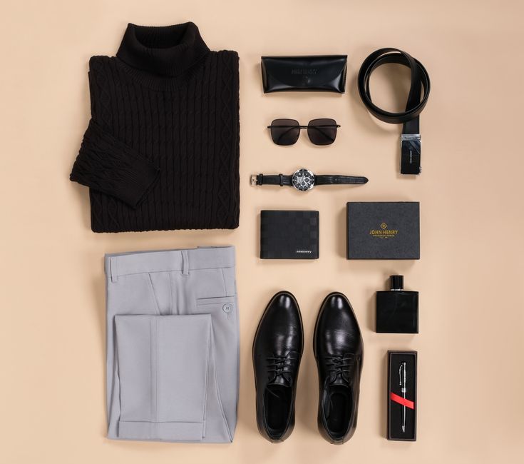 A flat lay of a minimalist business travel capsule wardrobe featuring neutral-colored shirts, a blazer, dress pants, and two pairs of shoes, ready for a trip.