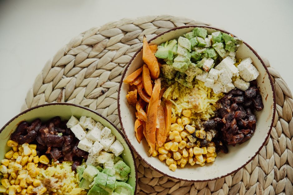 Overhead shot of a large, colorful salad bowl packed with mixed greens, various vegetables, chickpeas, and a light vinaigrette, representing a healthy lunch.