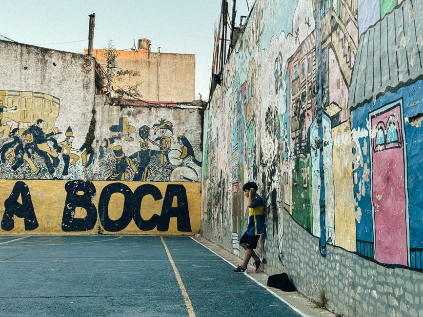 Vibrant street art murals adorning buildings in the San Telmo neighborhood of Buenos Aires, depicting local culture.