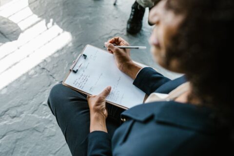 A consultant intently writing notes on a whiteboard, surrounded by markers and flowcharts, illustrating strategic planning for service page content.