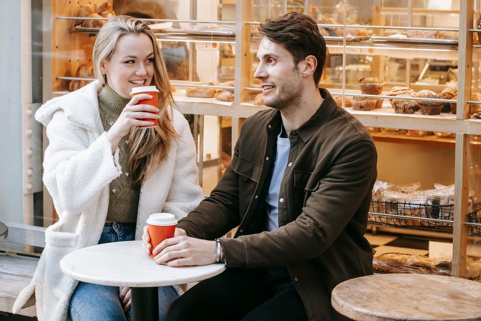 A couple sitting at an outdoor cafe in a charming European city, enjoying coffee and conversation, with no rush.