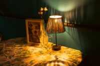 A cozy dining table bathed in soft evening light, set simply with placemats and candles, evoking a sense of calm.