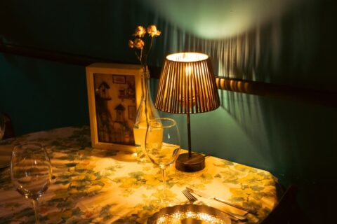 A cozy dining table bathed in soft evening light, set simply with placemats and candles, evoking a sense of calm.