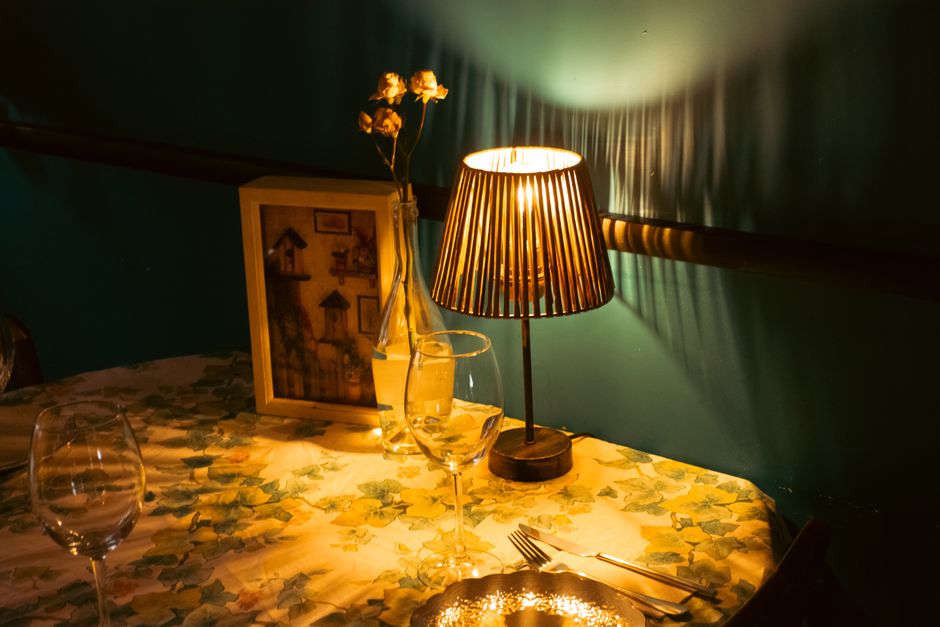 A cozy dining table bathed in soft evening light, set simply with placemats and candles, evoking a sense of calm.