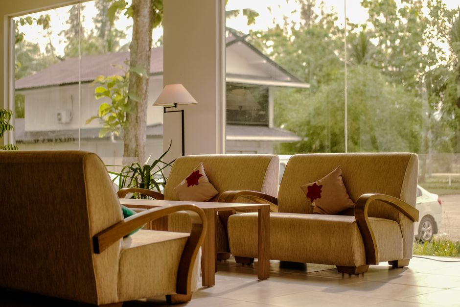 A warmly lit, stylish boutique hotel lobby with comfortable armchairs, a coffee table, and unique art, inviting guests to relax.
