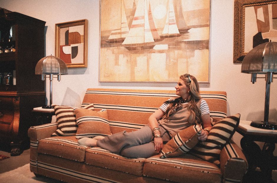 A tastefully decorated living room featuring a comfortable sofa, a textured throw blanket, a few curated books, and soft lighting, creating an inviting atmosphere.