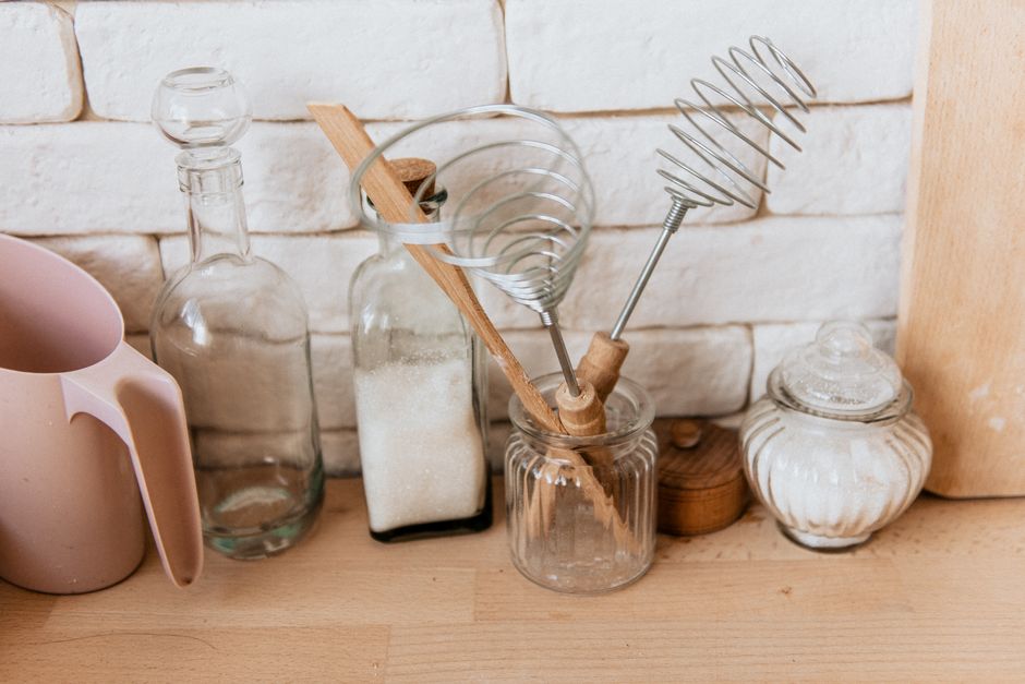 A tidy kitchen counter with a few essential, high-quality items like a wooden cutting board, a well-placed plant, and a simple ceramic mug, illustrating a decluttered space.