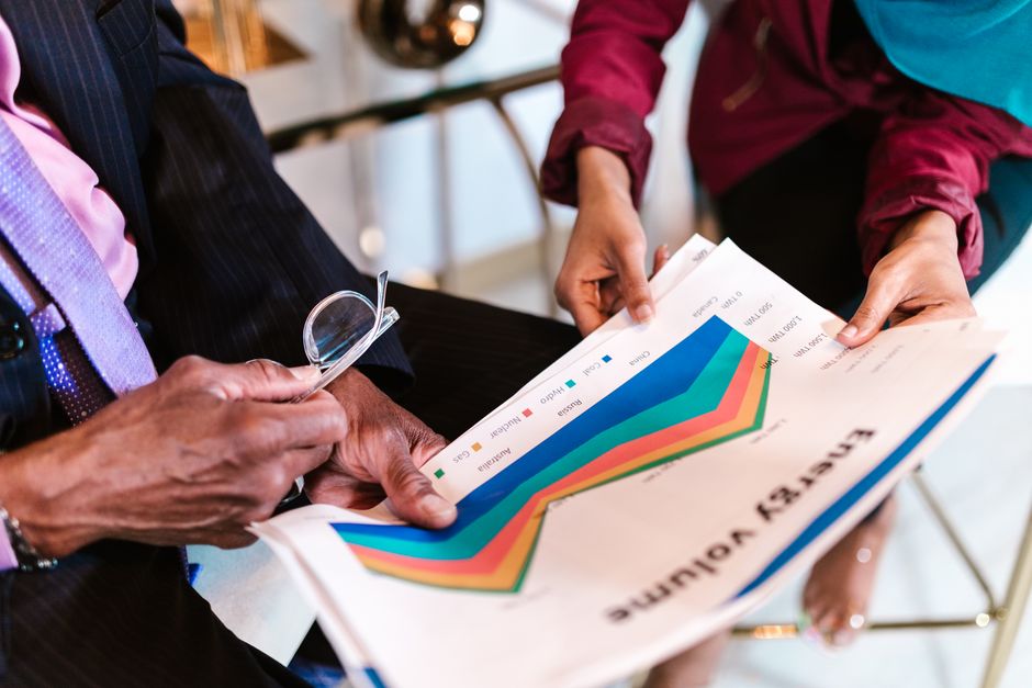 A diverse group of business professionals in a meeting, brainstorming ideas with charts and graphs.