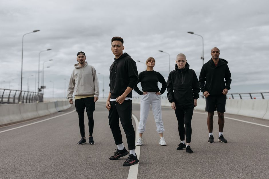A diverse group of adults, including men and women over 35, walk confidently down a bustling city street, each wearing comfortable and stylish denim that complements their shape.