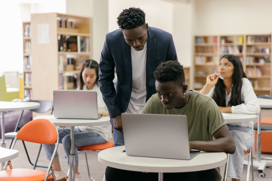 A diverse group of students from different continents (Europe, North America, South America) collaborating and comparing AI tools on their laptops and tablets, symbolizing the global reach and varied applications of AI for everyday users.