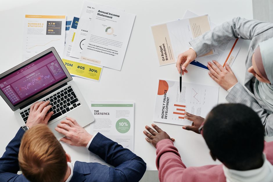Three professionals, representing various roles, reviewing a digital report that visualizes AI recommendations, fostering clear communication and understanding.