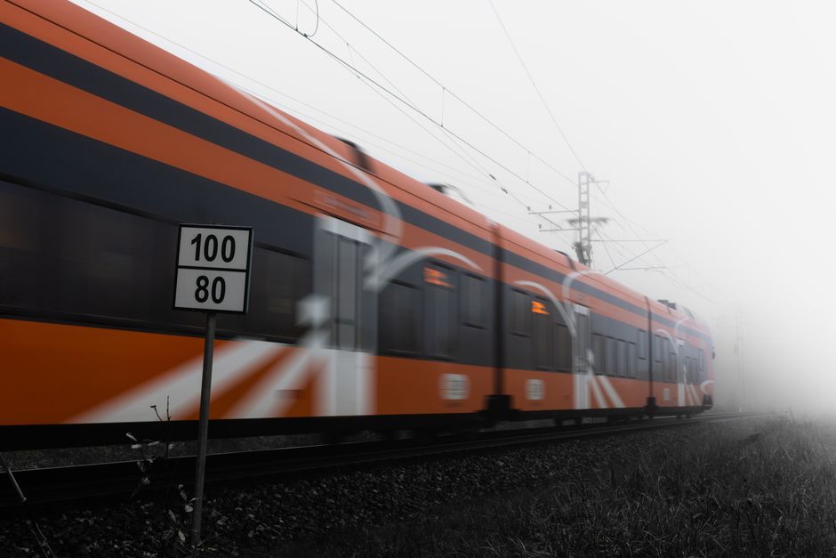 A sleek, high-speed train gracefully curves through a picturesque European countryside, illustrating efficient rail travel.