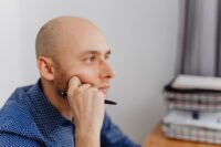 A person sitting at a desk, deep in thought, with multiple sticky notes representing different opportunities and decisions.
