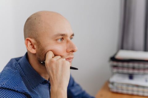 A person sitting at a desk, deep in thought, with multiple sticky notes representing different opportunities and decisions.