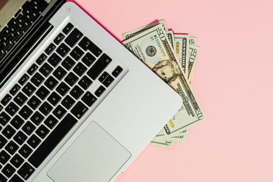 A focused freelancer working from a modern home office with multiple screens, illustrating diversified work and digital tools.