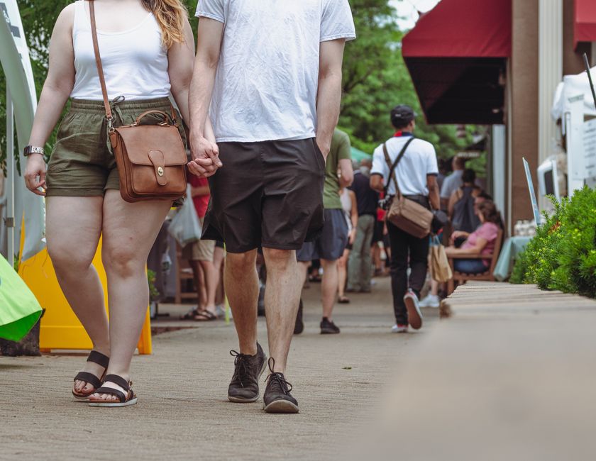 Friends enjoying a sunny day at a bustling European market, dressed in casual yet chic weekend market outfits.