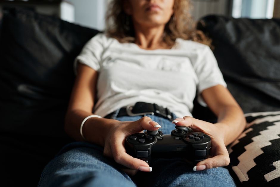 A person comfortably lounging on a beanbag chair, holding a console controller, enjoying a peaceful gaming session at night.
