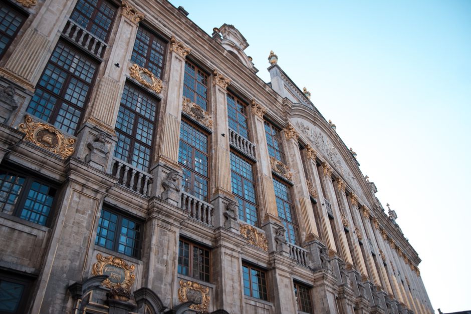 The illuminated Grand Place in Brussels during winter, surrounded by ornate guildhalls.