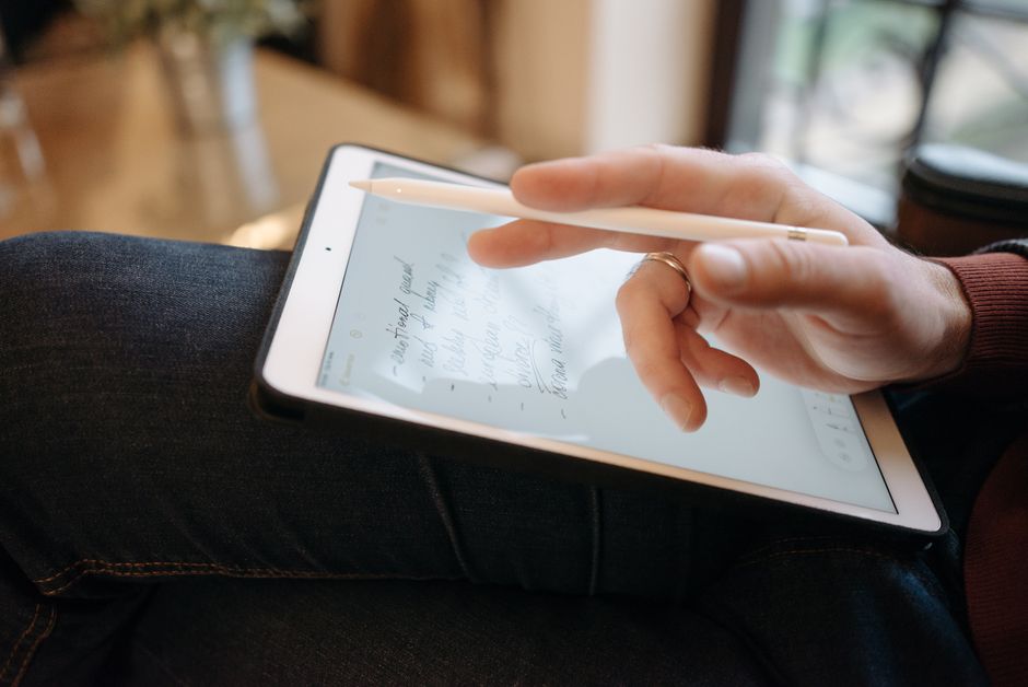 A close-up shot of a hand using a stylus to write notes on a tablet screen, illustrating precision and ease of use.
