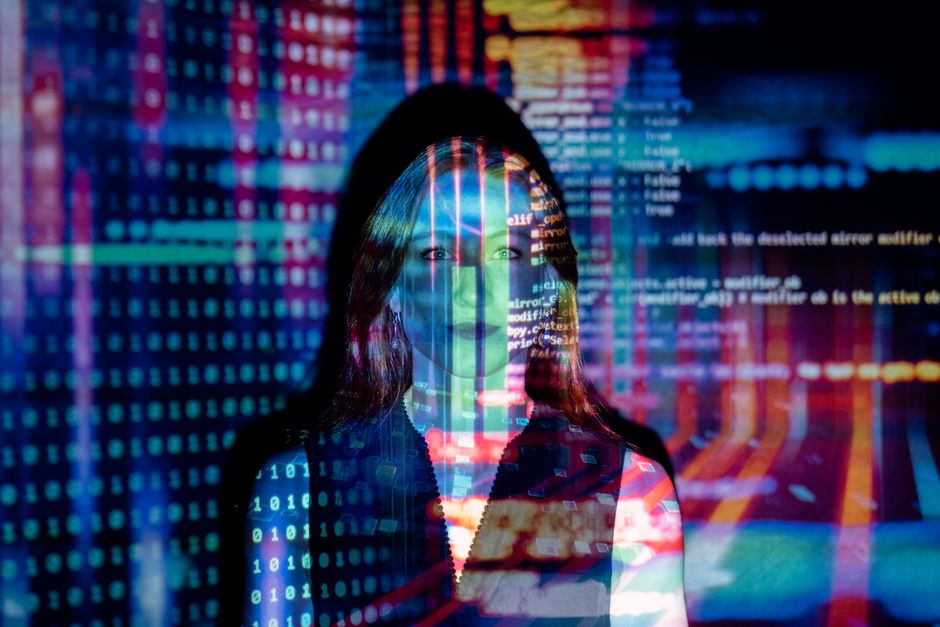 A person's hands delicately placing a magnifying glass over a printed document that has AI-generated text, while a laptop with AI tools runs in the background, representing critical human oversight of AI output.