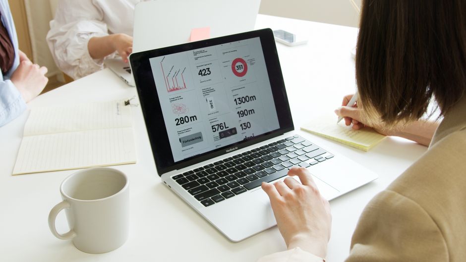Close-up of a laptop screen displaying website analytics and conversion metrics, with a person's hands nearby, symbolizing optimization of service pages.