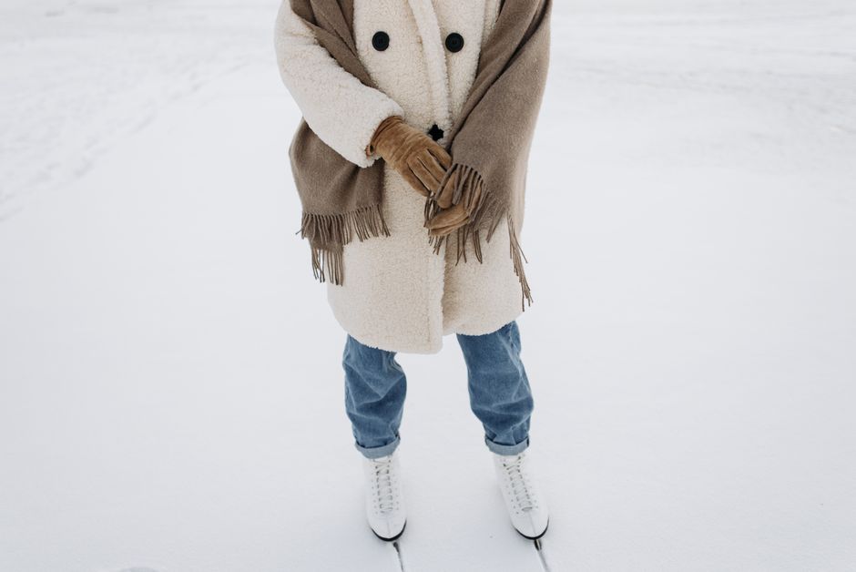 A neatly organized coat rack displaying a curated selection of coats: a classic trench, a dark wool coat, and a lightweight parka, symbolizing a streamlined four-season rotation.