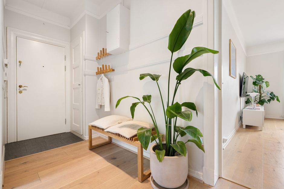 A clean, minimalist city apartment living room with light walls and a simple sofa, showcasing a calm and decluttered space.