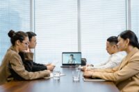 A diverse team from different global locations collaborating on a virtual video call, with multiple languages visible in chat bubbles, symbolizing the need for AI translation for multilingual teams.
