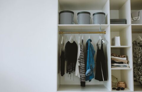 A neatly organized closet with clothes categorized by color and type, representing an efficient wardrobe.