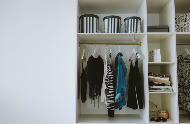 A neatly organized closet with clothes categorized by color and type, representing an efficient wardrobe.