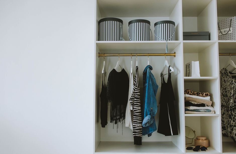 A neatly organized closet with clothes categorized by color and type, representing an efficient wardrobe.