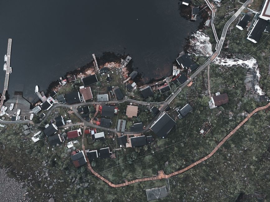 An aerial view of a colorful, tranquil landscape being built in a tile-placement puzzle game, representing grind-free gaming.