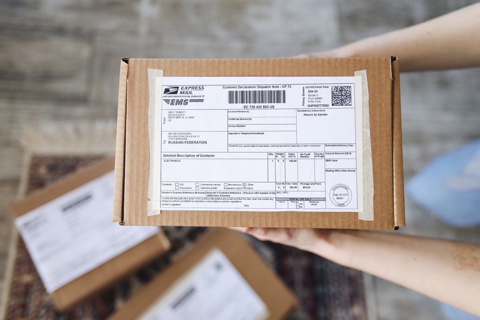 A stack of various-sized packages ready for shipping, each adorned with international customs declarations and destination labels for different countries.