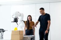 A person at a desk interacting with various digital interfaces, symbolizing human-AI collaboration in creative work.