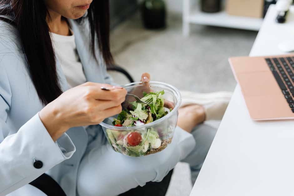A person enjoying a healthy, homemade lunch at their desk in an office setting