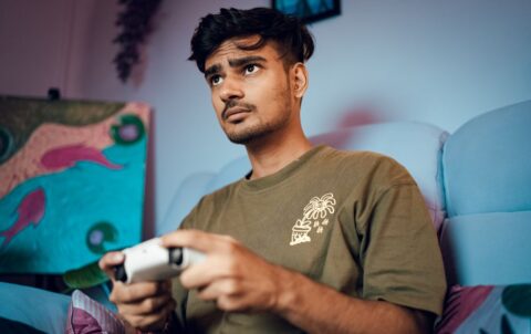 Person immersed in an atmospheric indie game on a console, showcasing unique art style.