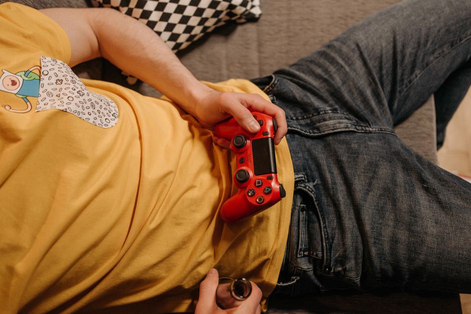 A person's hands holding a PlayStation controller, immersed in a story-driven game displayed on a TV screen.