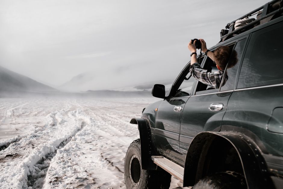 A lone photographer with a tripod captures the dramatic, fog-laden peaks of the Andes mountains in South America, showcasing atmospheric weather.