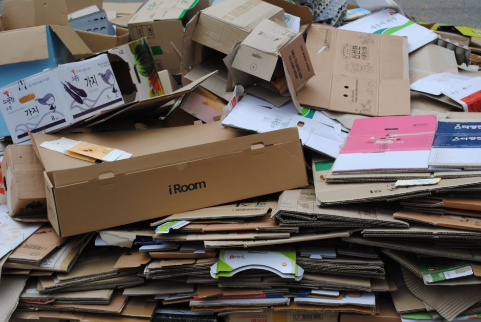 A symbolic pile of brightly colored, unopened software boxes and forgotten login cards, illustrating subscription bloat.