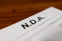 Close-up of a contract or policy document, with a pen, emphasizing the importance of privacy agreements for AI tools.