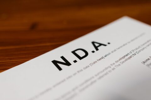 Close-up of a contract or policy document, with a pen, emphasizing the importance of privacy agreements for AI tools.