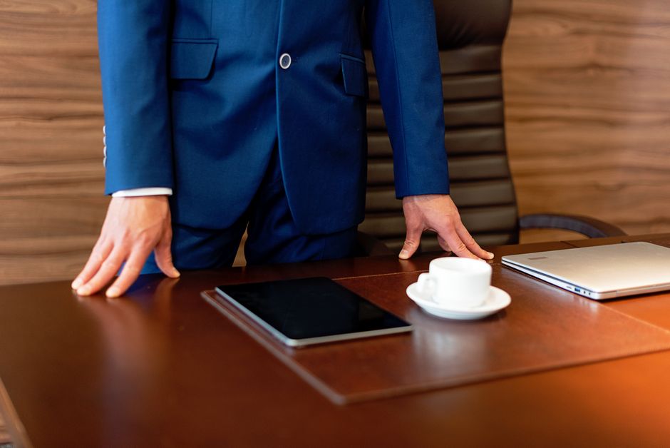 A professional reviews documents on a tablet and takes notes, preparing for a critical business meeting.