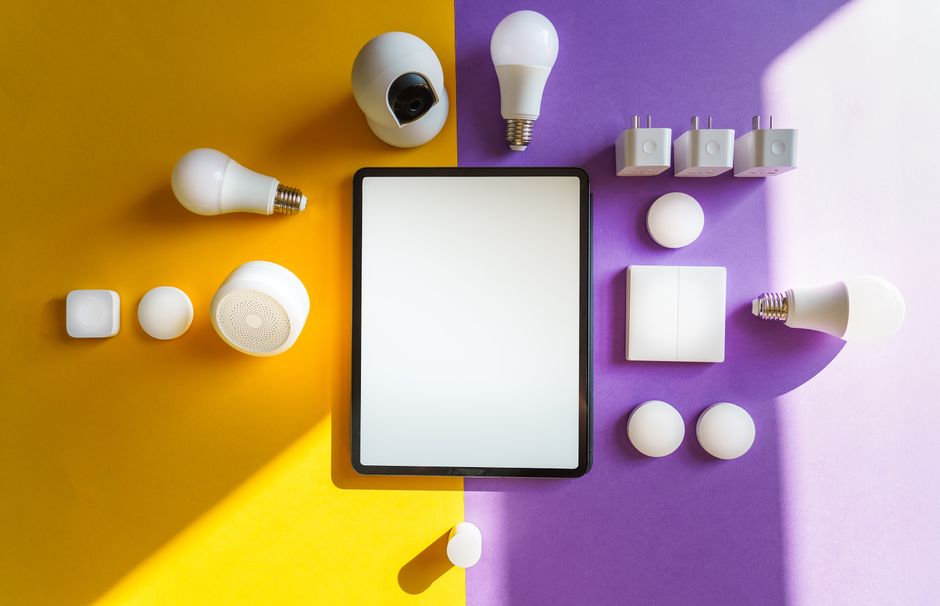 A collage of renter-friendly smart home gadgets including smart bulbs, a security camera, and a smart plug, neatly arranged on a table.