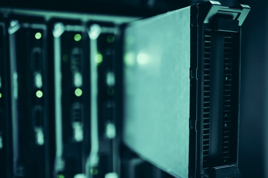 Row of blinking server racks in a data center, symbolizing secure, private AI infrastructure and data control.